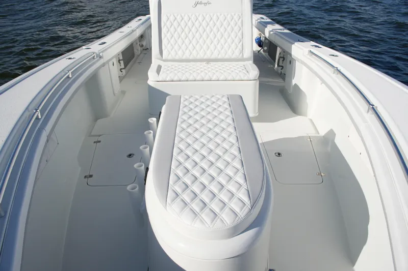 Slide: The Image of 2014 Yellowfin 32 Offshore boat interior with white quilted seating on open water. - 49