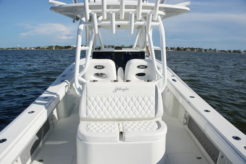 Slide: The Image of 2014 Yellowfin 32 Offshore boat interior with white seating on open water. - 54