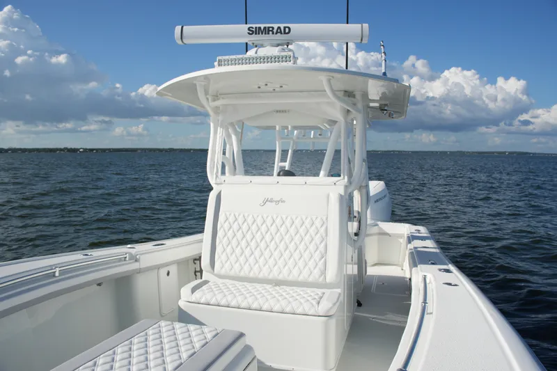 Slide: The Image of 2014 Yellowfin 32 Offshore boat on open water, featuring white seating and Simrad equipment. - 51