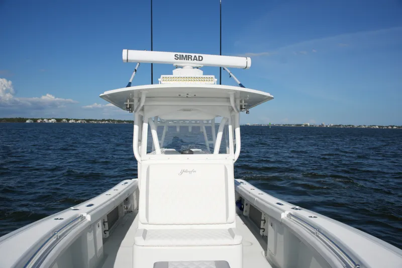Slide: The Image of 2014 Yellowfin 32 Offshore boat cruising on open water under clear blue skies. - 48