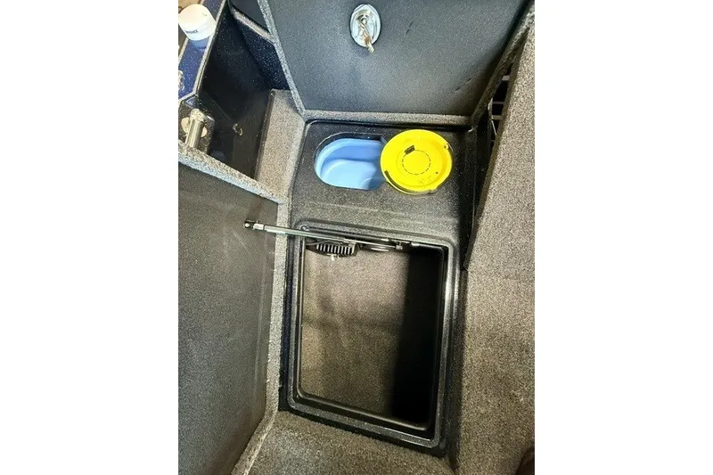 Slide: The Image of 2024 Nitro ZV20 boat storage compartment with key lock and yellow cap. - 20
