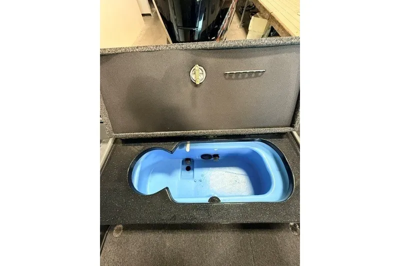 Slide: The Image of 2024 Nitro ZV20 boat livewell with open lid, showcasing blue interior. - 25