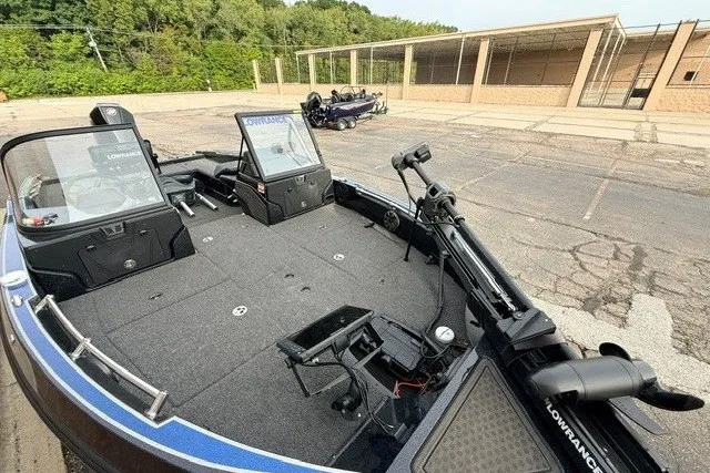 Slide: The Image of 2024 Nitro ZV20 fishing boat with spacious deck and advanced equipment in a parking area. - 13