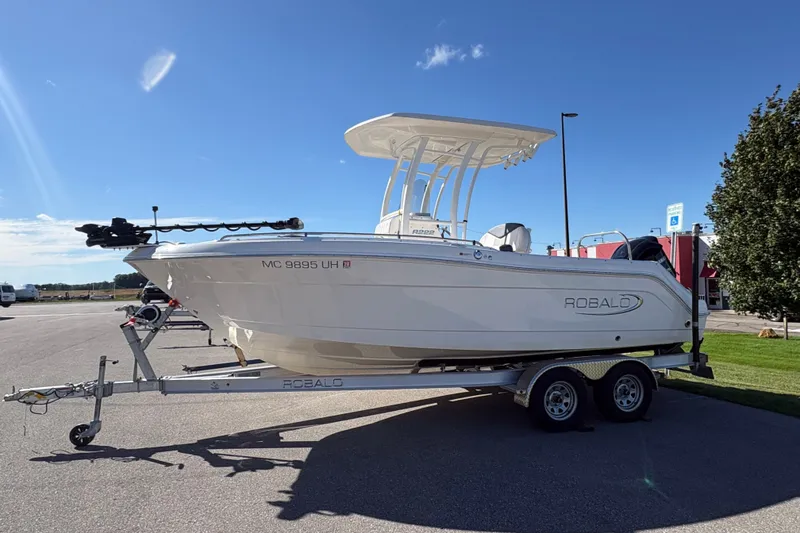 The Image of 2019 Robalo R222 Explorer boat on trailer under clear blue sky. - 4