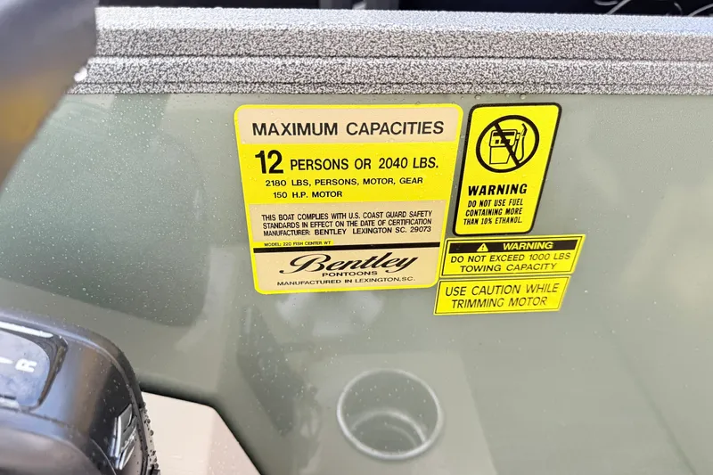 Slide: The Image of 2027 Bentley Pontoons Fish 220 FWD CW capacity label, 12 persons, 2040 lbs, safety warnings. - 10