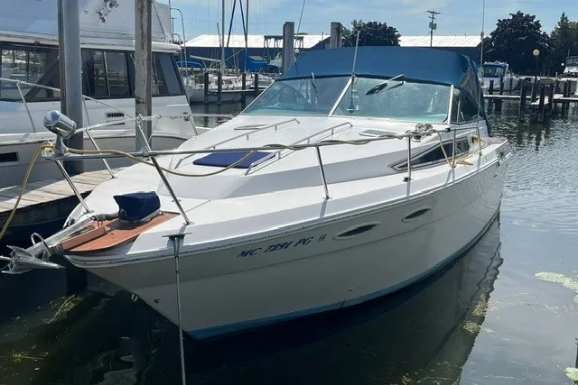 Slide: The Image of 1989 Sea Ray 300 Weekender boat docked in a marina, featuring a sleek white design. - 2