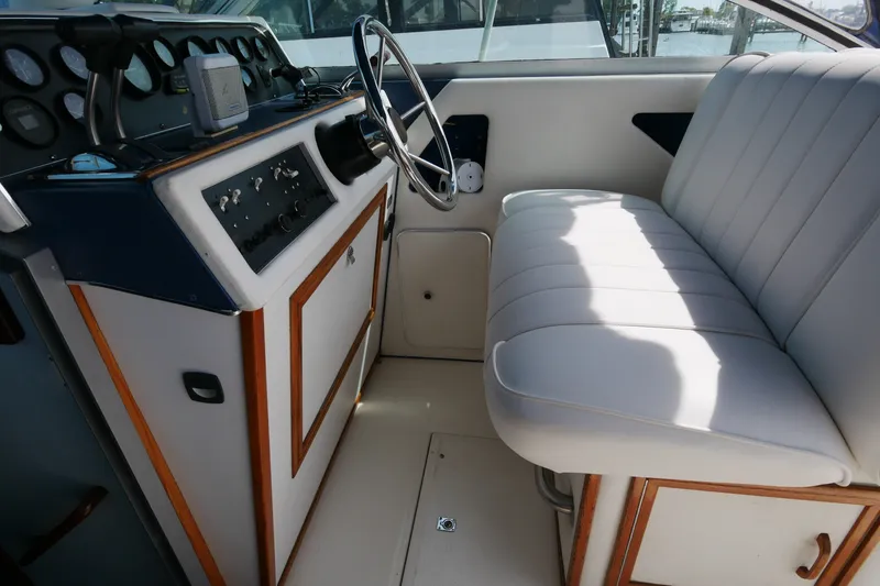 Slide: The Image of Interior of a 1989 Sea Ray 300 Weekender boat with steering wheel and seating. - 9