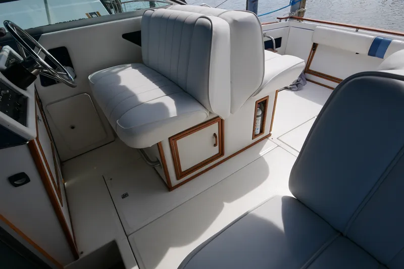 Slide: The Image of 1989 Sea Ray 300 Weekender boat interior with white seating and wooden accents. - 3