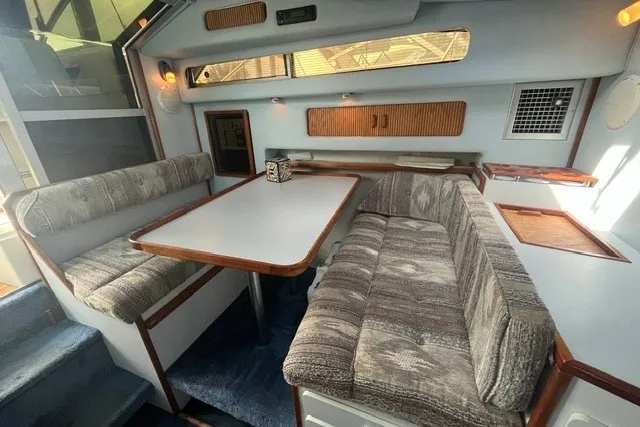 Slide: The Image of 1989 Sea Ray 300 Weekender interior with cozy seating and dining area. - 20