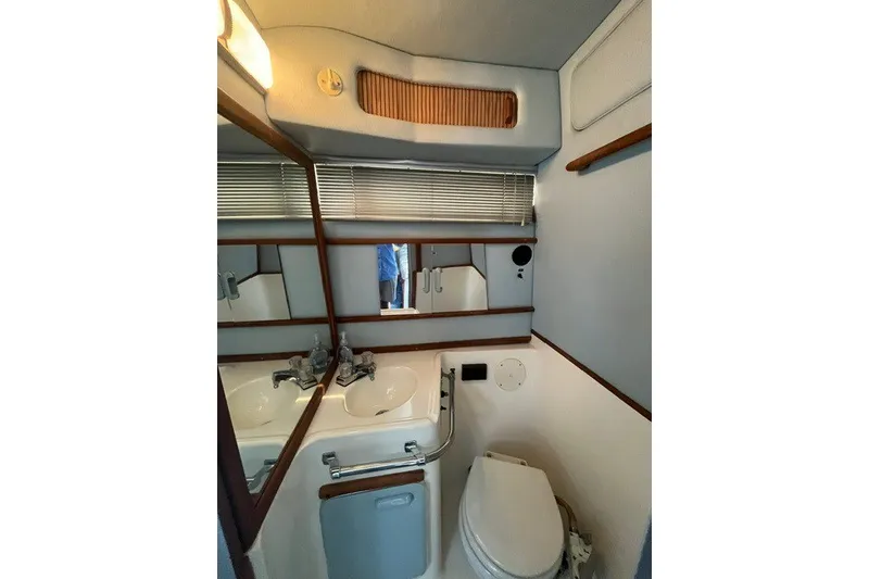 Slide: The Image of 1989 Sea Ray 300 Weekender bathroom with sink, mirror, and toilet. - 29