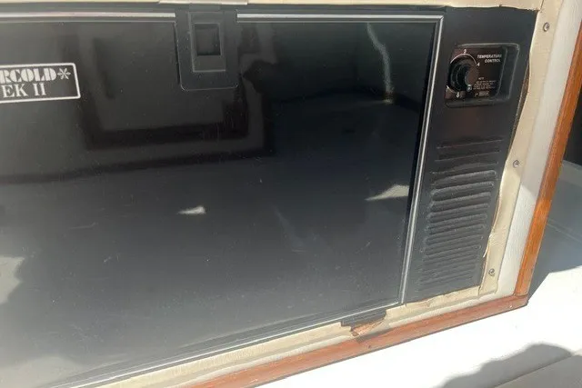 Slide: The Image of 1989 Sea Ray 300 Weekender boat refrigerator with temperature control knob. - 18