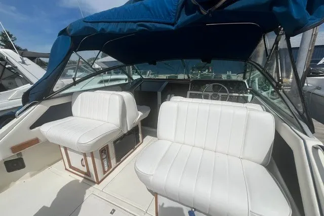 Slide: The Image of 1989 Sea Ray 300 Weekender boat interior with white seating and blue canopy. - 5