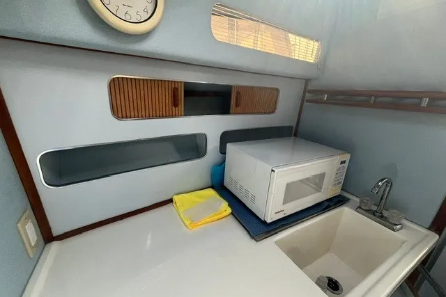 Slide: The Image of Interior of 1989 Sea Ray 300 Weekender with microwave, sink, and storage compartments. - 22