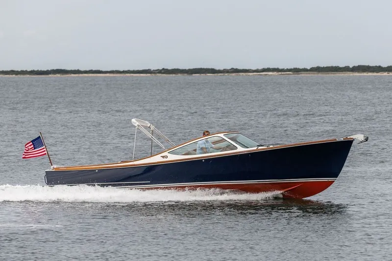 The Image of 2025 Hinckley Yachts Talaria 29 Runabout cruising on open water with American flag. - 0