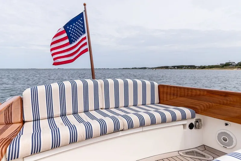 Slide: The Image of Hinckley Yachts Talaria 29 Runabout 2025 with striped seating and American flag on open water. - 18