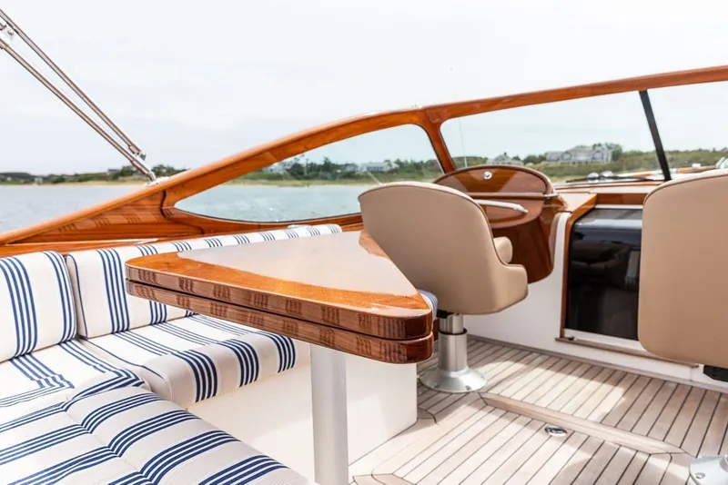 Slide: The Image of 2025 Hinckley Yachts Talaria 29 Runabout interior with striped seating and wooden accents. - 11