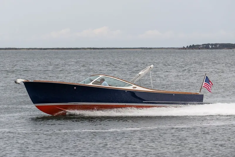 Slide: The Image of 2025 Hinckley Yachts Talaria 29 Runabout cruising on open water with American flag. - 28