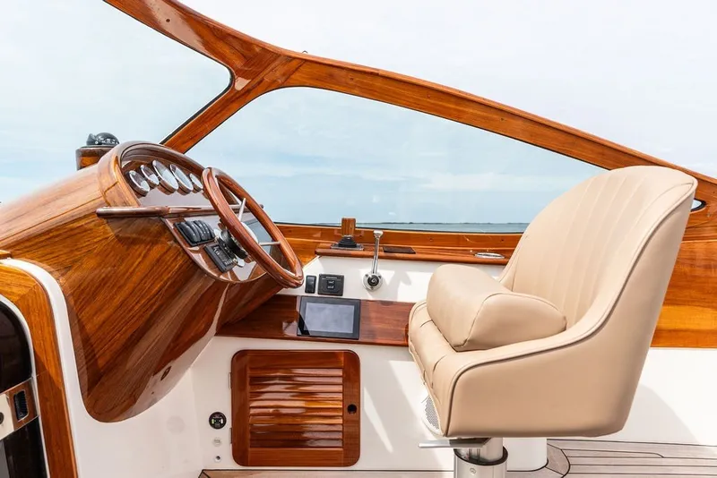 Slide: The Image of 2025 Hinckley Yachts Talaria 29 Runabout cockpit with luxurious wood finish and leather seating. - 5