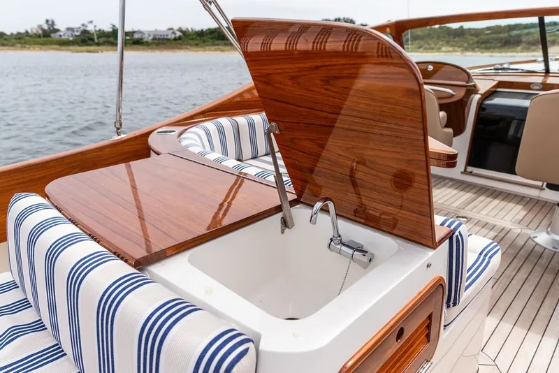 Slide: The Image of 2025 Hinckley Yachts Talaria 29 Runabout interior with striped seating and wooden accents. - 14