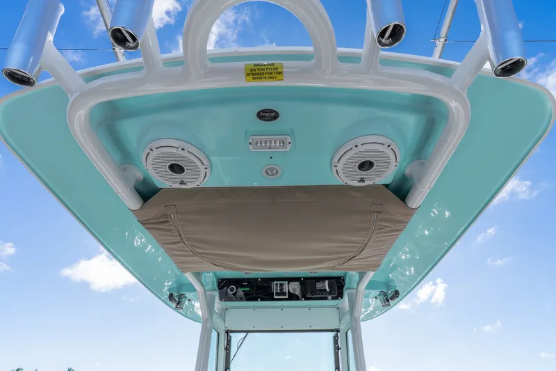 Slide: The Image of Everglades 253 Center Console 2020 boat roof with speakers and storage, under blue sky. - 25