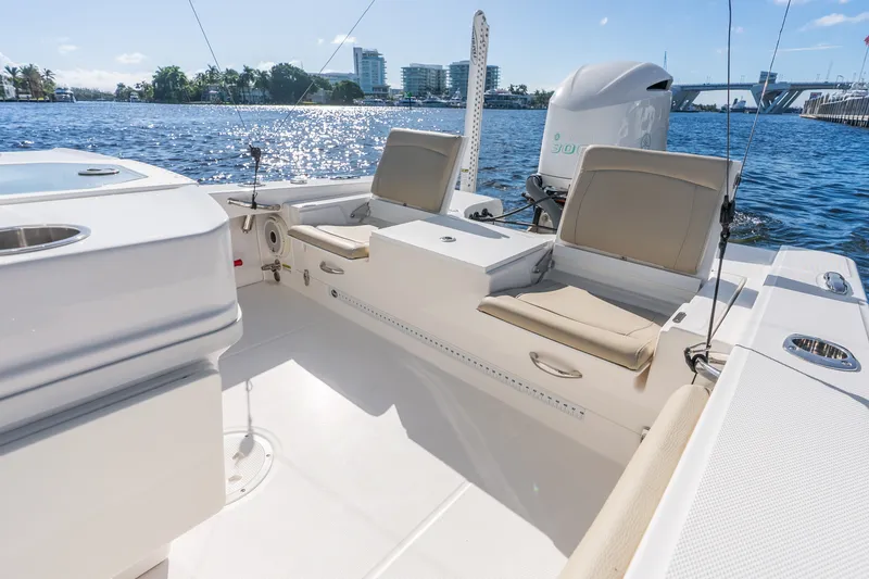 Slide: The Image of 2020 Everglades 253 Center Console boat interior with seating, on a sunny waterfront. - 44