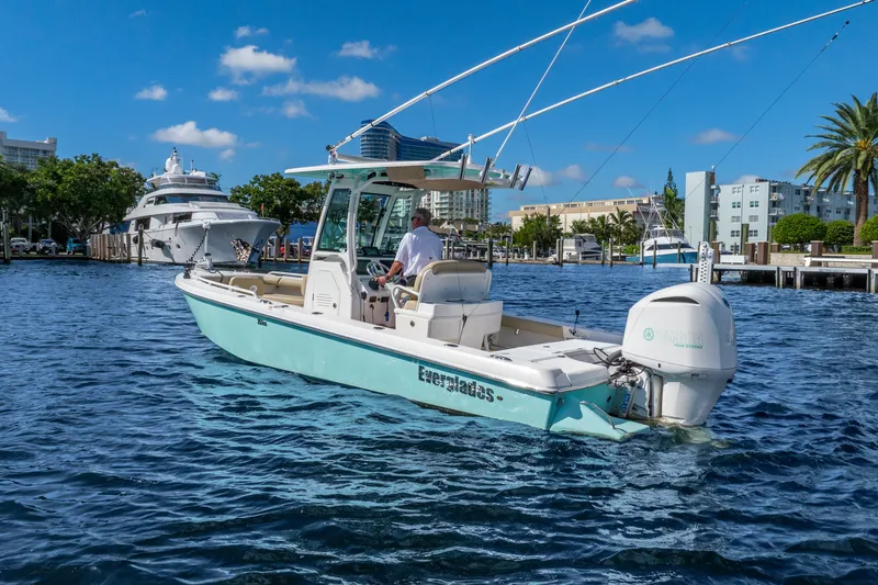 Slide: The Image of 2020 Everglades 253 Center Console boat cruising in a sunny marina. - 13