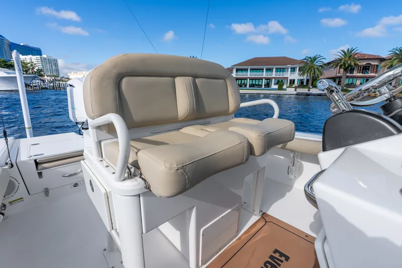 Slide: The Image of 2020 Everglades 253 Center Console boat interior with beige seating and waterfront view. - 23