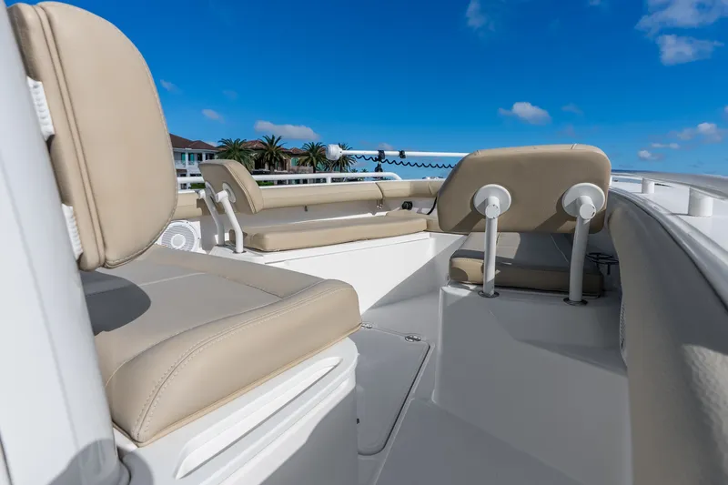Slide: The Image of 2020 Everglades 253 Center Console boat interior with beige seating under blue sky. - 27