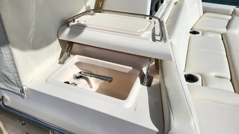 Slide: The Image of The image shows a sink on a boat, surrounded by white upholstery and stainless steel railings. - 27