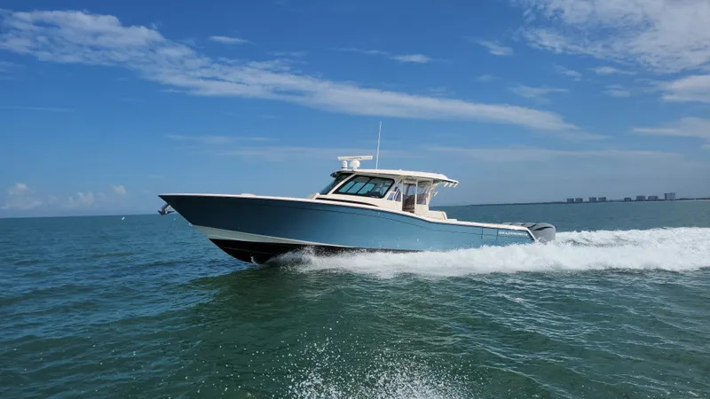 Slide: The Image of The 2022 Grady-White Canyon 456 speeds across the water under a clear blue sky. - 3