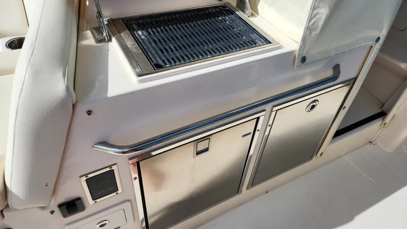Slide: The Image of The 2022 Grady-White Canyon 456 features an outdoor kitchen with a grill and storage space. - 26