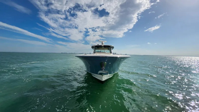 Slide: The Image of 2022 Grady-White Canyon 456 on open water with blue sky and clouds. - 13