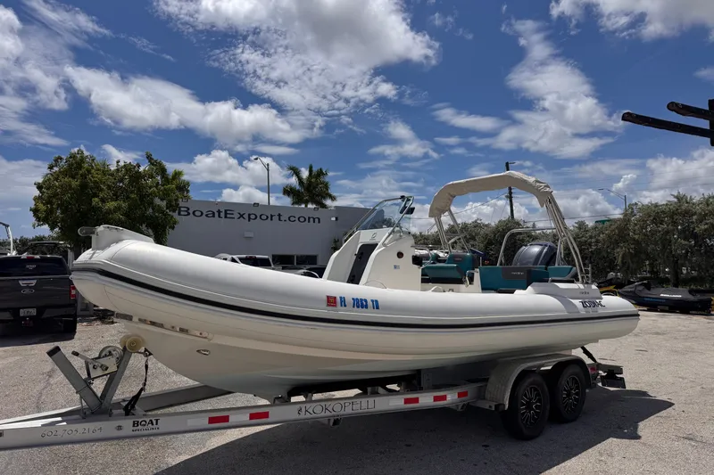 Slide: The Image of 2022 Zodiac Medline 6.8 boat on trailer at BoatExport.com under a partly cloudy sky. - 2
