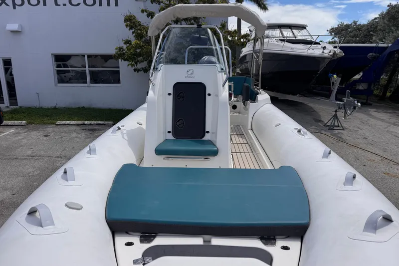 Slide: The Image of 2022 Zodiac Medline 6.8 inflatable boat with teal seating, docked outdoors. - 13