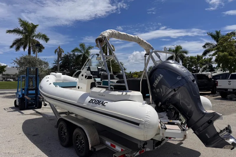 Slide: The Image of 2022 Zodiac Medline 6.8 boat on trailer with Yamaha engine, parked near palm trees. - 3