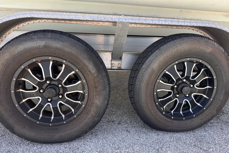 Slide: The Image of Trailer wheels of a 2022 Zodiac Medline 6.8, featuring stylish black rims. - 6