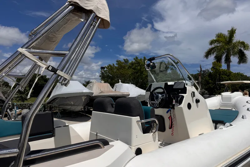 Slide: The Image of 2022 Zodiac Medline 6.8 boat with console and seating, under a clear blue sky. - 8