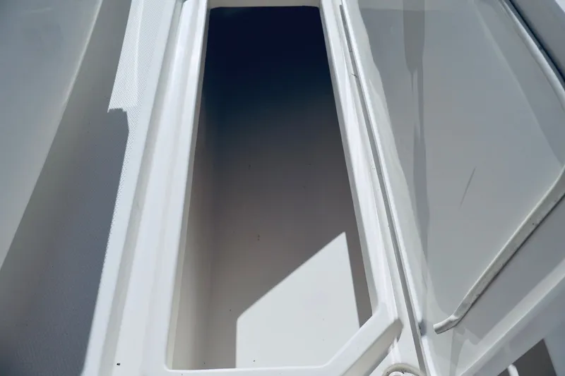 Slide: The Image of Storage compartment of a 2010 Deep Impact 330 C boat, featuring a sleek white interior. - 46