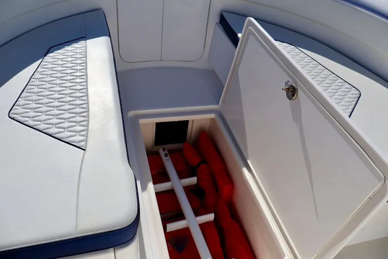 Slide: The Image of Open storage compartment on 2010 Deep Impact 330 C boat with life jackets inside. - 47