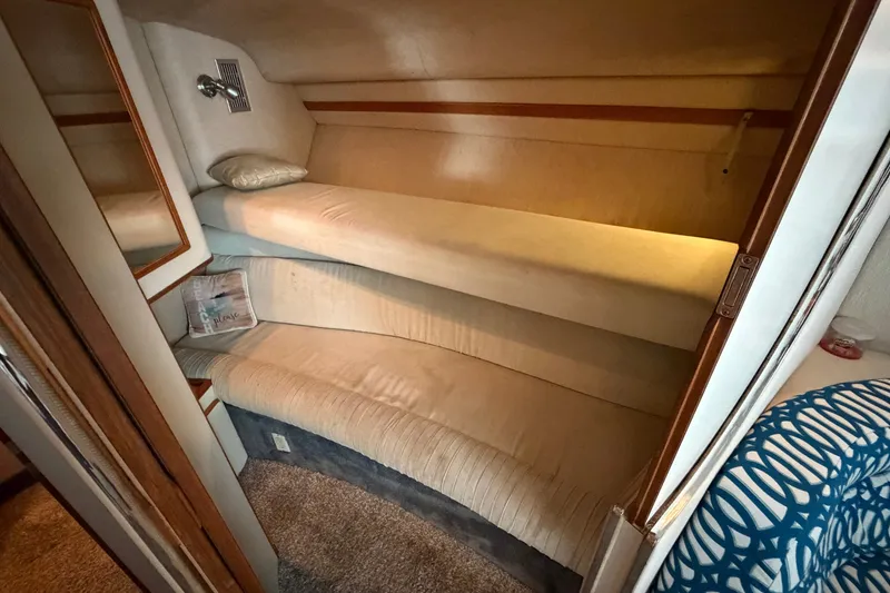 Slide: The Image of 1993 Sea Ray 400 Express Cruiser cabin with cozy bunk beds and soft lighting. - 18