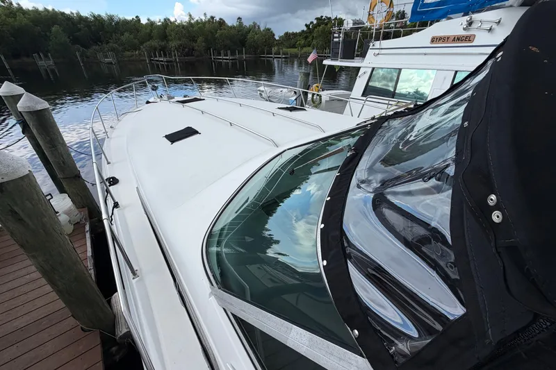 Slide: The Image of 1993 Sea Ray 400 Express Cruiser docked by a serene waterfront. - 7