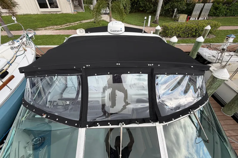 Slide: The Image of 1993 Sea Ray 400 Express Cruiser with black canvas top docked at marina. - 5