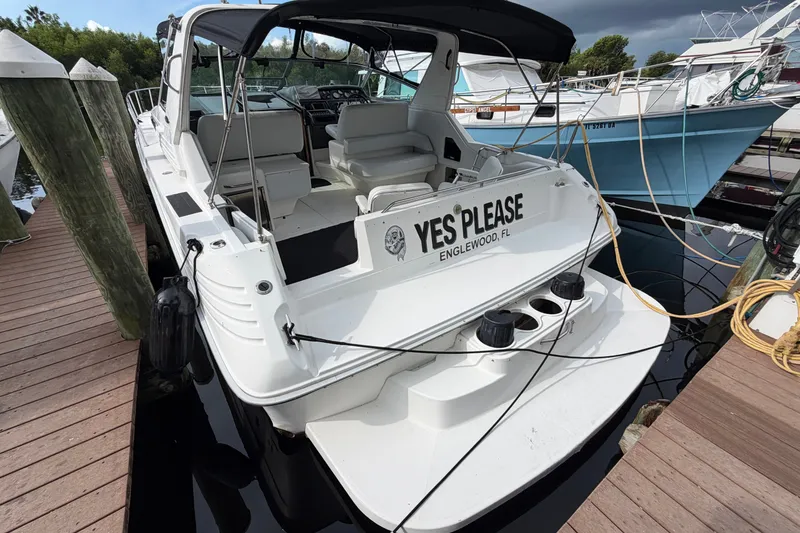 Slide: The Image of 1993 Sea Ray 400 Express Cruiser docked, rear view with "Yes Please" nameplate. - 1