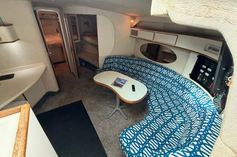 Slide: The Image of Interior of 1993 Sea Ray 400 Express Cruiser with blue patterned seating and table. - 13