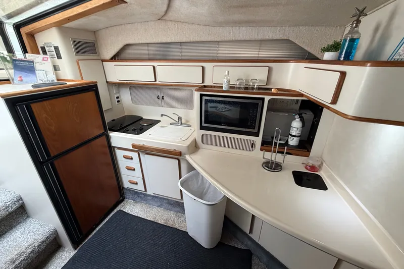 Slide: The Image of Interior of 1993 Sea Ray 400 Express Cruiser kitchen with appliances and storage. - 16