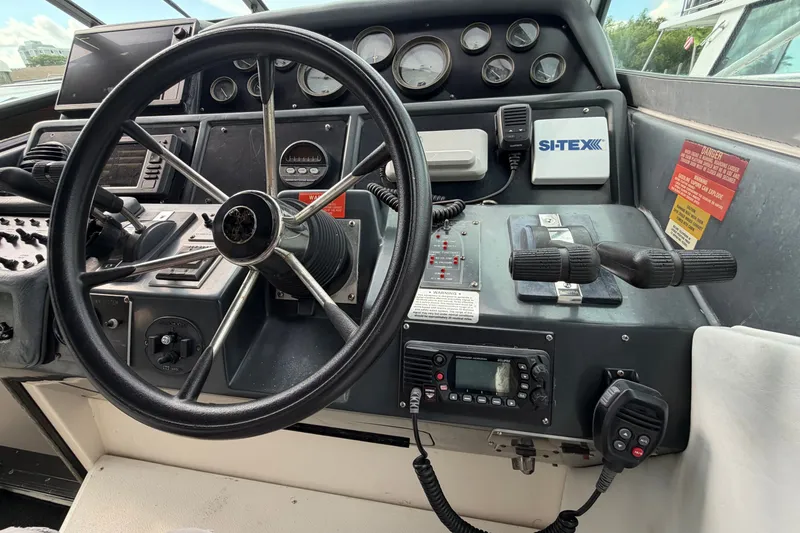 Slide: The Image of 1993 Sea Ray 400 Express Cruiser helm with steering wheel and navigation controls. - 12