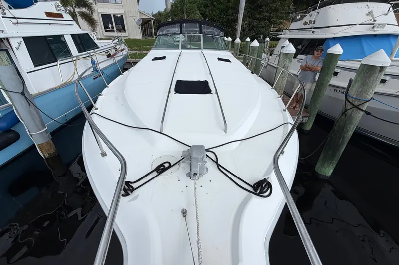 Slide: The Image of 1993 Sea Ray 400 Express Cruiser docked at marina, showcasing sleek white deck design. - 2