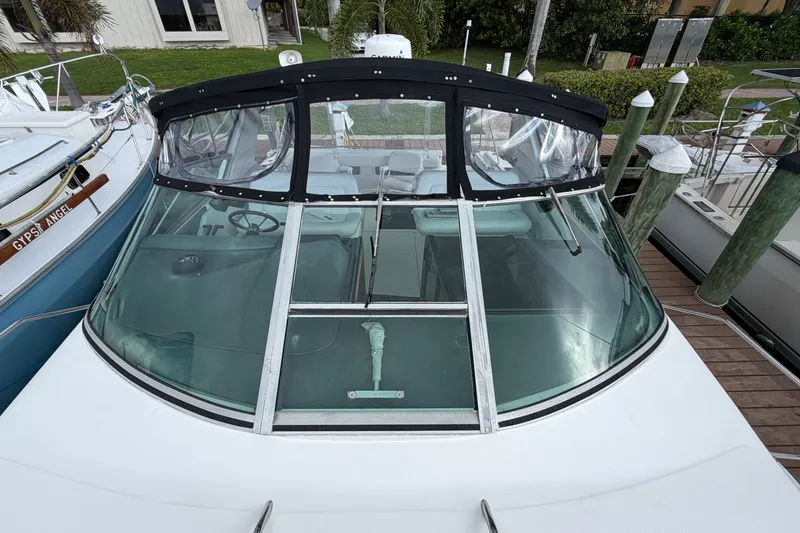 Slide: The Image of 1993 Sea Ray 400 Express Cruiser docked, featuring a sleek windshield and black canopy. - 4