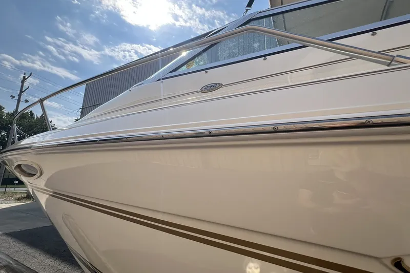 Slide: The Image of 1997 Sea Ray 240 Overnighter boat under a sunny sky, showcasing sleek design and detailing. - 81