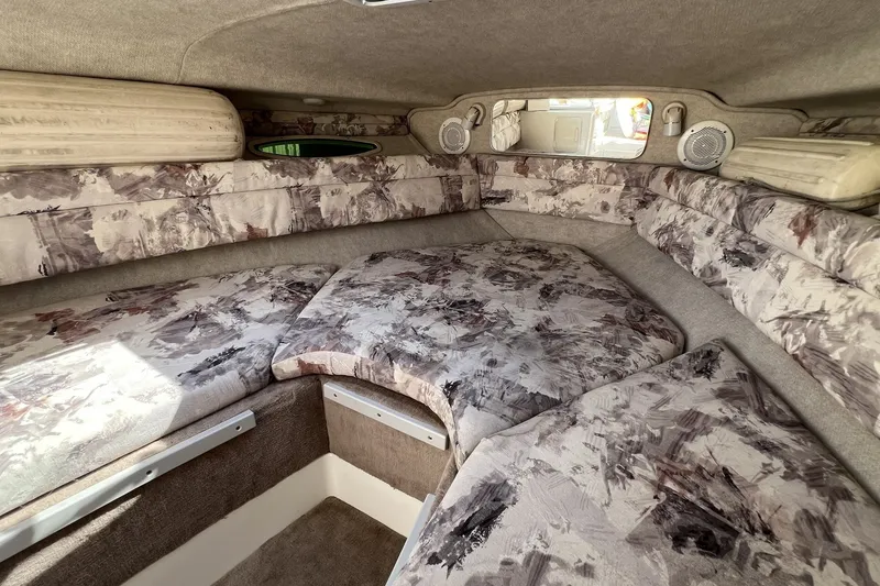 Slide: The Image of 1997 Sea Ray 240 Overnighter cabin interior with patterned upholstery and cozy sleeping area. - 56